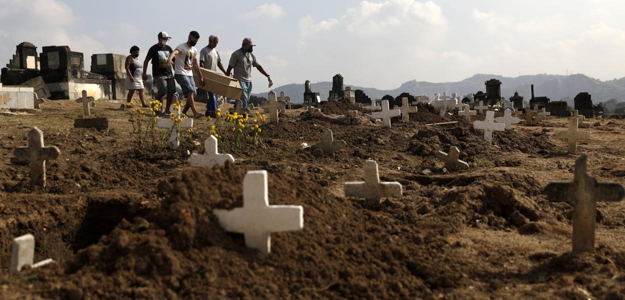 Marcos Vinicius Andrade da Silva, 26, ajuda a carregar no Cemitério de Inhauma o caixão de Valnir Mendes da Silva, 62, que morreu em uma calçada na favela Arará após dificuldades para respirar, em meio à pandemia do novo coronavírus. Rio de Janeiro, Brasil, 18/05/2020.