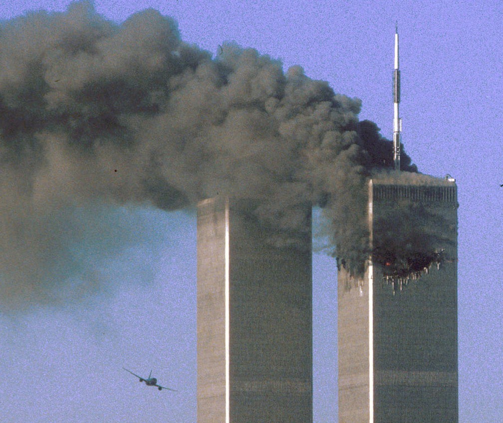 Segundos antes, avião do voo 175 da United Airlines é visto se aproximando da Torre Sul do WTC, em Nova York, enquanto a Torre Norte pega fogo, durante os ataques terroristas do 11 de Setembro - Foto: Sean Adair/Reuters/Arquivo