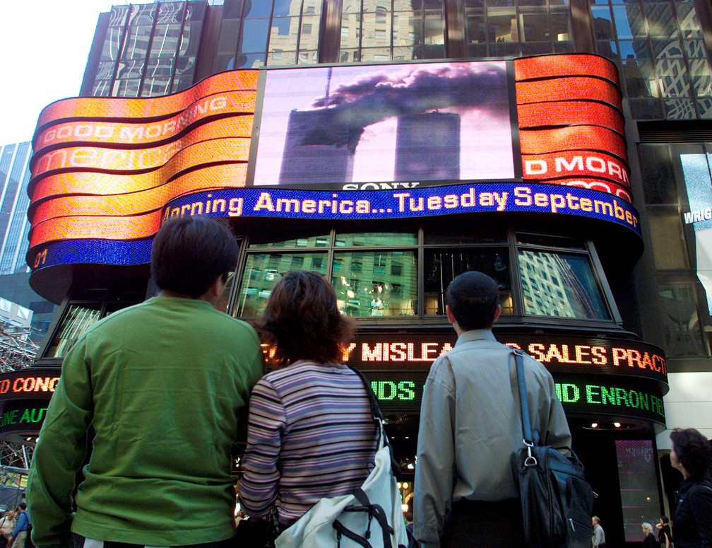 Pessoas assistem telão na Times Square, no Centro de Manhattan, mostrando o World Trade Center em chamas na parte sul da ilha antes de a segunda torre ser atingida - Foto: Shannon Stapleton/Reuters/Arquivo