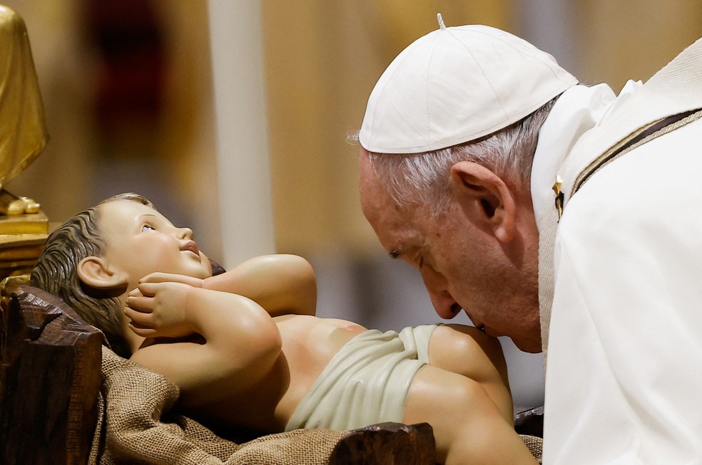 Papa Francisco beija estátua do menino Jesus durante a Santa Missa da véspera de Natal, na Basílica de São Pedro, em 24 de dezembro de 2021 no Vaticano - Foto: Guglielmo Mangiapane/Reuters