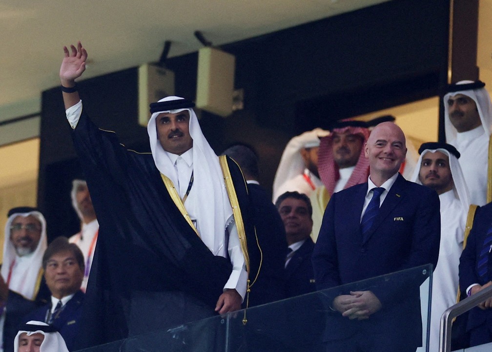 Tamim bin Hamad al-Thani, emir do Catar, acena ao lado do presidente da Fifa, Gianni Infantino, abertura da Copa neste domingo (20), em Doha - Foto: Kai Pfaffenbach/Reuters