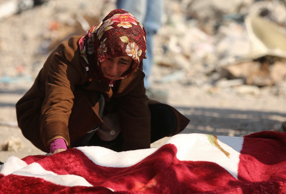 Mulher chora sobre corpo de vítima encontrada em escombros causados por terremoto na Turquia - Foto: Reuters