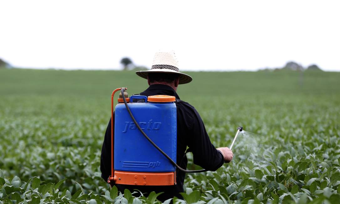 Câmara aprova flexibilização de uso de agrotóxicos. Na foto, Adilson Pagani, 45 anos, produtor de soja com bomba costão sem EPI Foto: Michel Filho / Agência O Globo